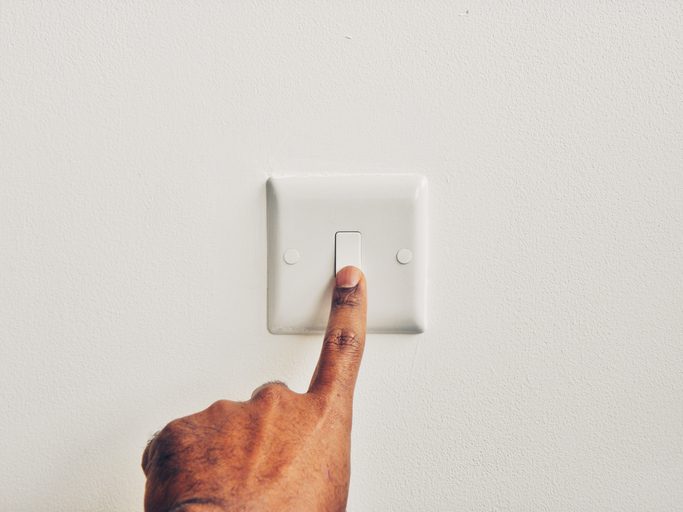 Polk Electric LLC | Cropped Hand Of Man Pressing Switch Board Against Wall